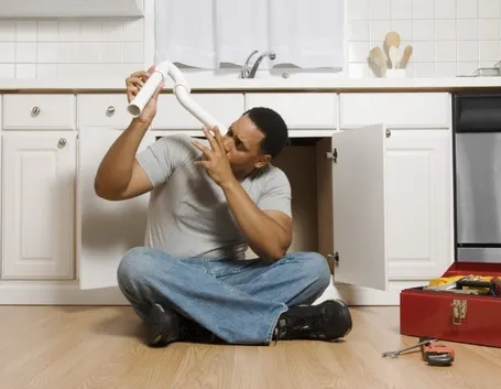 Uomo di casa alle prese con idraulica fai da te