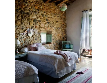 Stanza da letto con parete in pietra