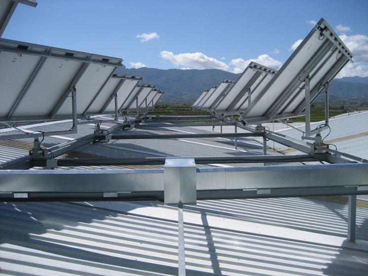 Pannelli con inseguitori solari (solar trackers) installati sul tetto di un capannone